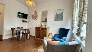 a living room with a blue couch and a table at Belle échappée in Le Crotoy