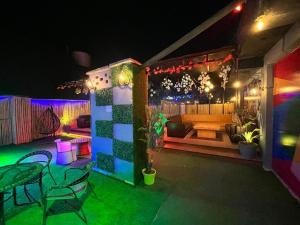a patio with a table and chairs at night at Hotel Grand Father in Agra