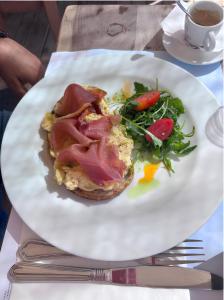 a plate with a sandwich and salad on a table at Casa Frati Suites & Villas in Perivolos