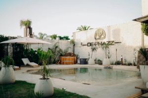 a pool in front of a building with an umbrella at DePhazz I Wellness Clinic & Spa in Junín
