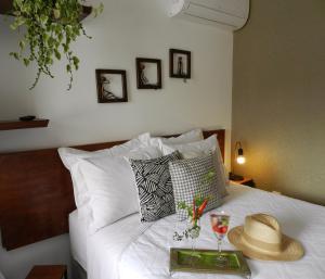 ein Bett mit einem Tablett, auf dem ein Hut und eine Brille liegen in der Unterkunft Hospedaria Canto do Vinhedo in Espirito Santo Do Pinhal