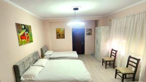 a bedroom with two beds and a table and chairs at ERLA'S apartment in Tirana