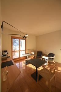 a living room with tables and chairs and a window at B&B Il Faggio Rosso in Vernante