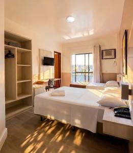 a hotel room with two beds and a window at Pousada Villa Atlântica in Balneário Camboriú +35 photos