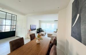 a living room with a table and chairs and a living room at MiMa Vakantiewoning bij Tomorrowland in Boom