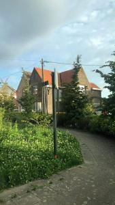 a street sign in the grass in front of a house at MiMa Vakantiewoning bij Tomorrowland in Boom