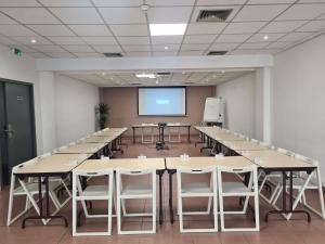 a conference room with tables and a projection screen at Ibis Budget Toulon Centre in Toulon