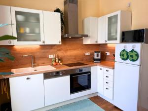 a kitchen with white cabinets and a sink at Ferienwohnung am Maximilianpark Hamm - Dachterrasse, Highspeed-WLAN, 2 Schlafzimmer in Hamm