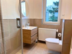 a bathroom with a sink and a toilet and a window at Ferienwohnung am Maximilianpark Hamm - Dachterrasse, Highspeed-WLAN, 2 Schlafzimmer in Hamm