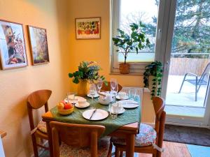 a dining room table with plates and wine glasses at Ferienwohnung am Maximilianpark Hamm - Dachterrasse, Highspeed-WLAN, 2 Schlafzimmer in Hamm