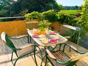 a wooden table with four chairs on a patio at Ferienwohnung am Maximilianpark Hamm - Dachterrasse, Highspeed-WLAN, 2 Schlafzimmer in Hamm