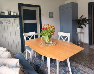 a wooden table with a vase of flowers on it at Pastor's Stuv Das Alte Pastorat in Uelvesbüll +18 photos