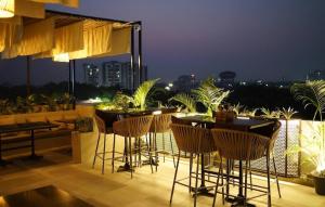 a patio with chairs and tables on a balcony at night at Hotel BR international in Tājganj +10 photos