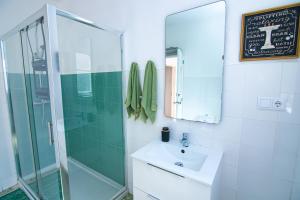 a bathroom with a shower and a sink and a mirror at Guest House D'Avenida in Vila Praia de Âncora +19 photos
