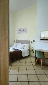 a bedroom with a bed and a desk and a chair at Dimora Sole del Sud in Ugento