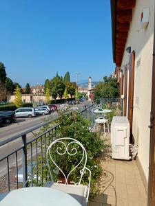 a balcony with a bench and tables and a street at Camera Lucy in Bardolino +5 photos