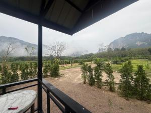 a balcony with a view of a field of trees at Nordic Mountain View in Ban Khlong Chi Lat