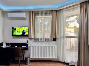 a living room with a tv and a table and a window at Lotus House in Hermina-major +45 photos