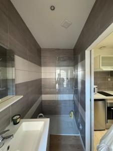a bathroom with a shower and a sink and a tub at Le refuge in Bellême