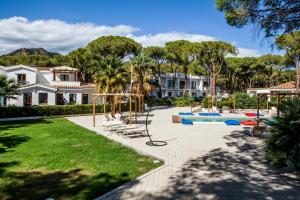 a playground in a yard with a house at Hotel New Barcavela in Santa Margherita di Pula