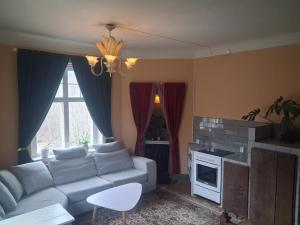 a living room with a couch and a stove at Singel room in big house in Molkom