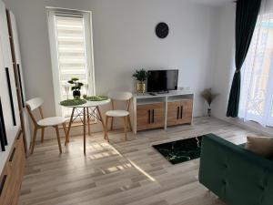ein Wohnzimmer mit einem Tisch und einem Fernseher in der Unterkunft SunSet Studio by Cosmopolis in Ştefăneştii de Sus + 13 Fotos