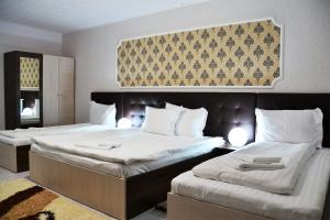 A bed or beds in a room at Pensiunea Alexander
