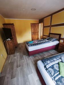 a room with two beds and a tv in it at Ferienwohnung Leon in Heldburg