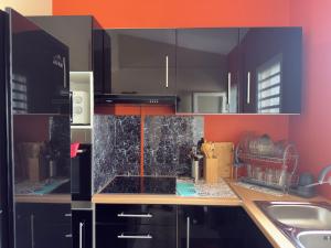 a kitchen with black cabinets and a granite counter top at Residence Cikaline Chambre d'hôte proximite du port de P-a-P in Pointe-à-Pitre +30 photos