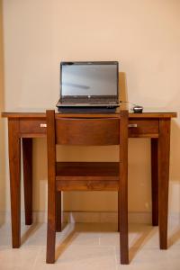 un computer portatile seduto sopra una scrivania in legno di Bugambilias Suites a Loreto