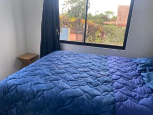 a blue bed in a bedroom with a window at Coral Breeze in Puntarenas +33 photos