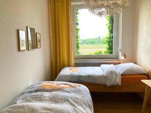 two beds in a room with a window at Ferienwohnung am Maximilianpark Hamm - Dachterrasse, Highspeed-WLAN, 2 Schlafzimmer in Hamm +77 photos