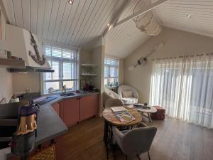a kitchen and living room with a table and chairs at Beach House Texel in De Koog