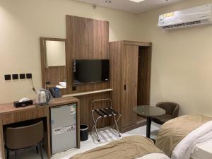 a hospital room with a bed and a flat screen tv at منازل الثقة in An Nikāshah