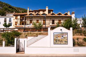 a large house on a hill with a gate at Hotel Rural Huerta del Laurel in Monachil