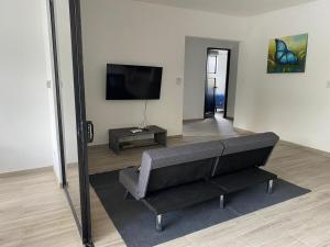 a living room with a couch and a flat screen tv at Coral Breeze in Puntarenas