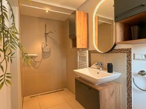 a bathroom with a sink and a mirror at Lütte Stuv Das Alte Pastorat in Uelvesbüll +10 photos