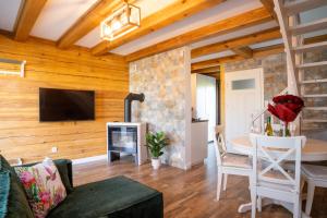 a living room with a table and a fireplace at Przy Rozlewisku in Sarbinowo