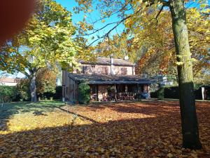 a house with leaves on the ground in front of it at Il Giardino di Dede in Ferrara