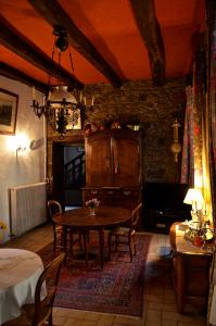 a dining room with a table and a stone wall at Maison de Benedicte in Saint-Brieuc