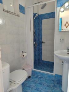 a bathroom with a shower and a toilet and a sink at Corali Hotel in Piso Livadi +39 photos