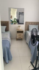 a bedroom with two beds and a fan at Apartamento em Condomínio Clube Completo com Piscina in Vitória da Conquista