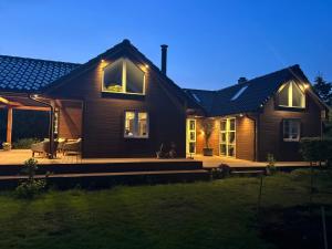 a house with a deck at night at Luxury Nature Retreat in Gilleleje