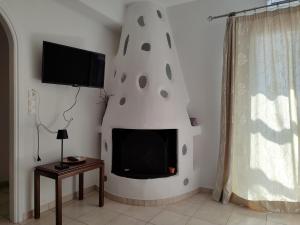 a living room with a tv and a fireplace at Corali Hotel in Piso Livadi