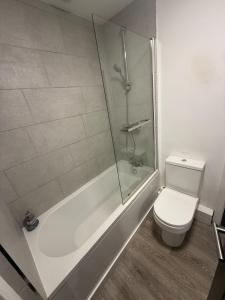 a bathroom with a tub and a toilet and a shower at Pool table-Pet Friendly-Beach access-Garden in Trearddur +23 photos