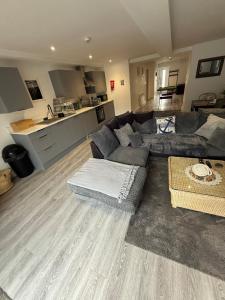 a living room with a couch and a kitchen at Pool table-Pet Friendly-Beach access-Garden in Trearddur