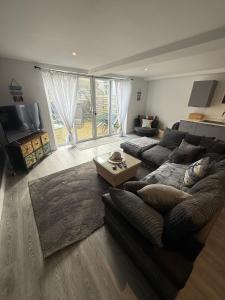 a living room with a couch and a table at Pool table-Pet Friendly-Beach access-Garden in Trearddur