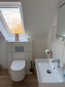 a bathroom with a white toilet and a window at Deich Winde 9.1 in Dorum-Neufeld +12 photos