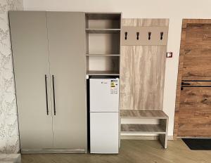 a kitchen with a refrigerator and a cupboard at KOLESEY Hotel in Taldykorgan