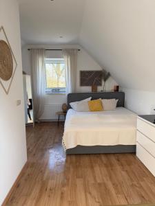 a bedroom with a large bed and a window at Deich Winde 9.1 in Dorum-Neufeld